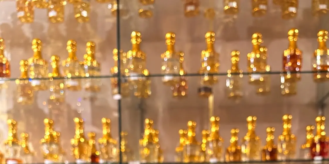Die Regalwand im Laden, Reihe für Reihe goldene Flakons